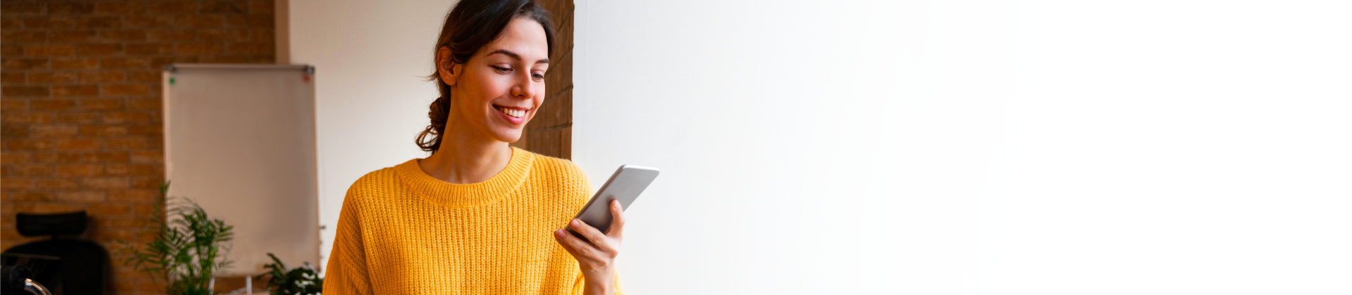 banner de mujer con un celular de la sección tutoriales del banco hipotecario canales digitales