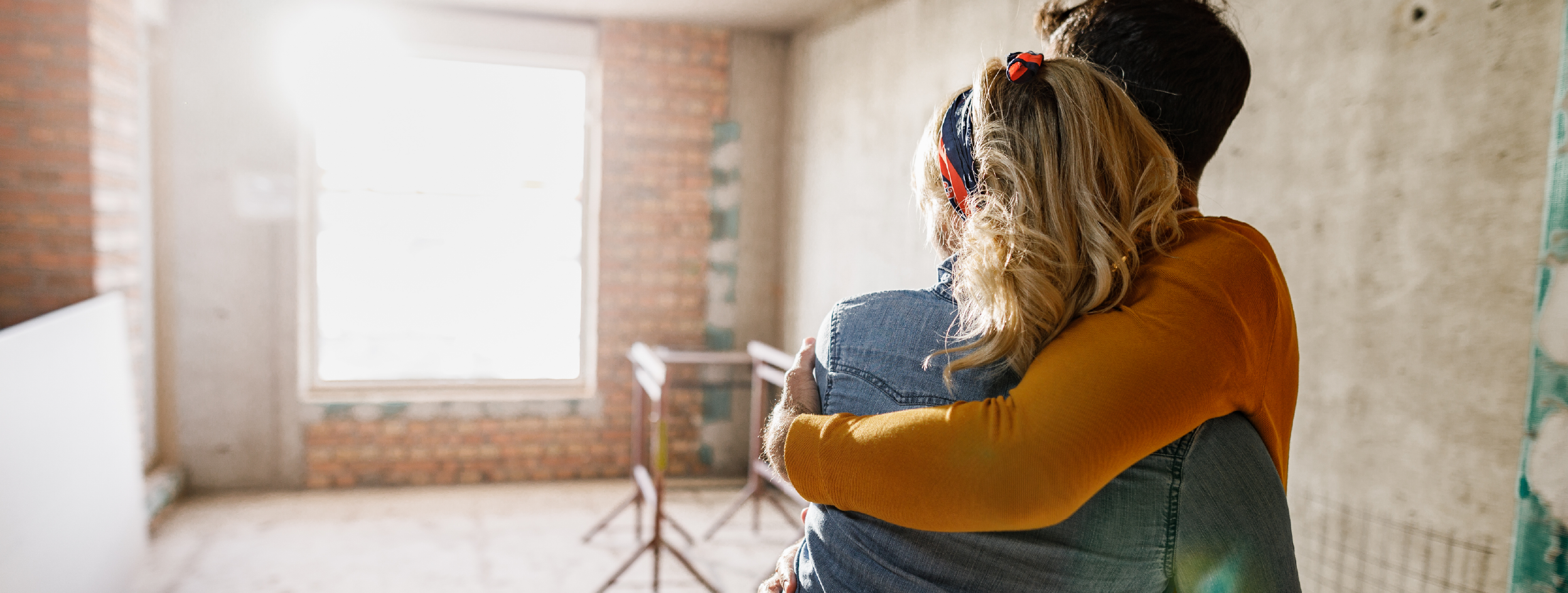 hombre y mujer felices mirando su casa en contrucción